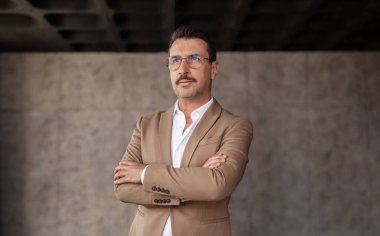 Şirket Liderliği. Başarılı orta yaşlı iş adamının portresi ofiste el ele tutuşuyor, ciddi bir ifadeyle kameraya bakıyor, gözlük takıyor.