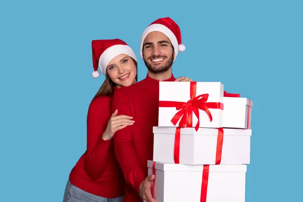 Happy Young Couple Holding Stack Van Kerstcadeaus Glimlachen Bij Camera — Stockfoto