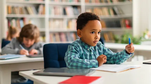 Black Schoolboy Attentively Listening Teacher Lesson Primary Classroom Exemplifying Earnest — Stock Photo, Image