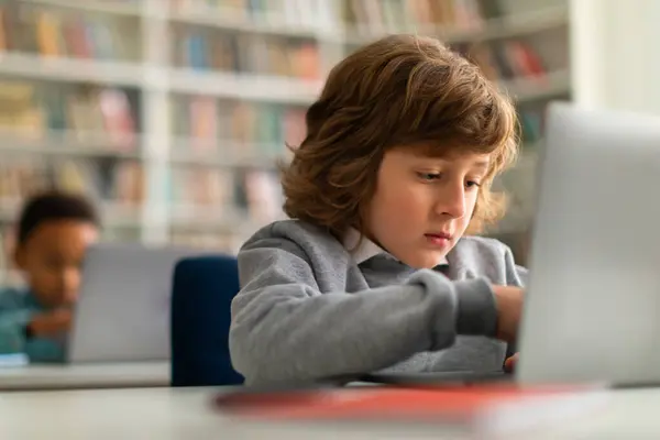 在一个明亮而充满活力的小学课堂环境中 在互动的教育课程中 让学童坐在课桌前 浏览笔记本电脑 探索数字世界 — 图库照片