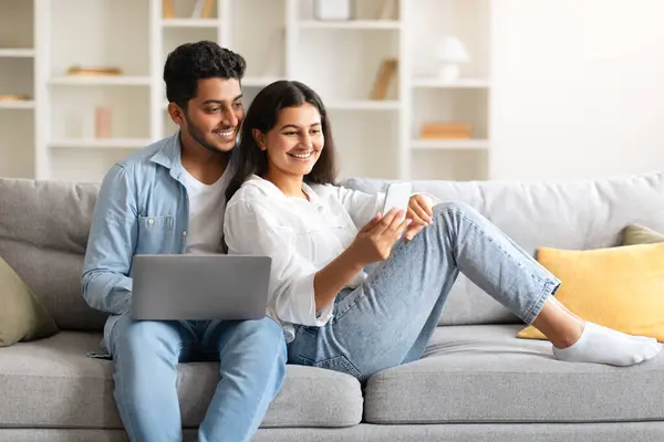 Young Indian Couple Leisurely Spend Time Sofa Delighting Using Laptop — Stock Photo, Image
