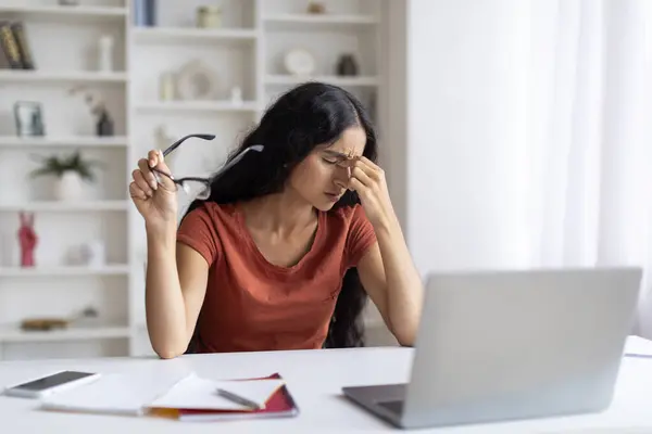 Tired Young Indian Woman Feeling Eyes Strain After Using Laptop At Home, Millennial Eastern Lady Freelancer Sitting At Desk With Computer At Home Office And Rubbing Eyelids, Copy Space