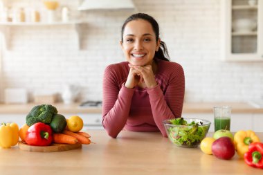 Genç kadın mutfak masasında poz veriyor taze organik sebzeler, sağlıklı yemekler, salata ve meyve suyu ile poz veriyor. Kolay Beslenme, Beslenme ve Refah