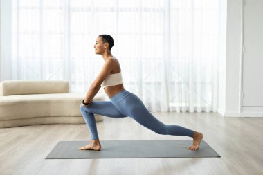 Spor kıyafetli, kısa saçlı genç latin bayanın oturma odasının içinde bacaklarının üzerinde egzersiz yapmasına sevindim. Profil. Evde spor, sağlık, kilo kaybı, spor