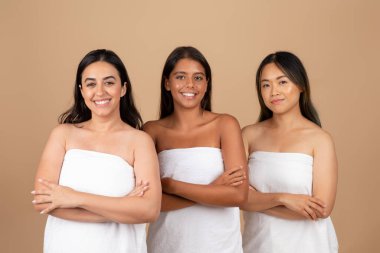 Her biri havluya sarılı çok ırklı kadınlar, rahatlatıcı ve iç açıcı çeşitlilik ve kapsama manzarası sunan güzelliğin bir örneğini sunuyorlar.