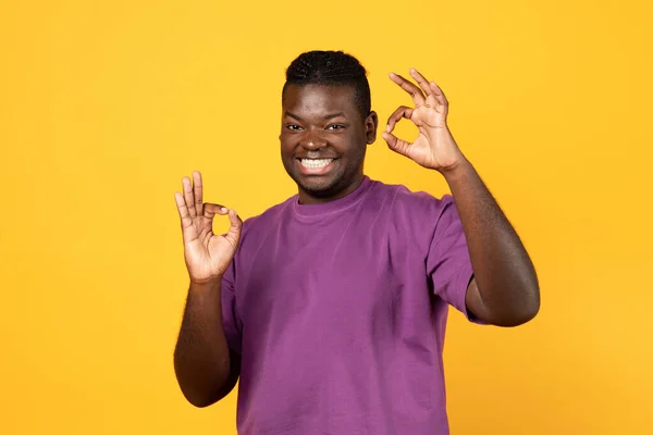 一切都很好兴奋的非洲裔美国男人表示 他可以用双手做一个认可的手势 对着镜头微笑 摆出一副黄色工作室的样子 穿上休闲装 — 图库照片