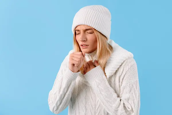 冬のセーターで悲しい病気の女性とインフルエンザと風邪に苦しむ帽子 ブルースタジオの背景に隔離 健康問題 病気治療 ブロンヒット — ストック写真