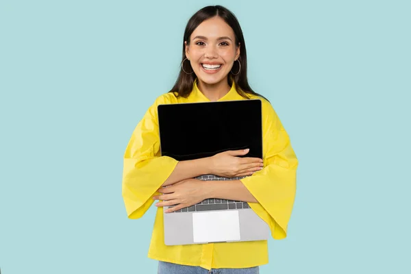 快乐快乐漂亮的黑发女数码游牧民族拥抱全新的笔记本电脑和微笑 隔离在蓝色的工作室背景 小武器上瘾 数字世界 — 图库照片