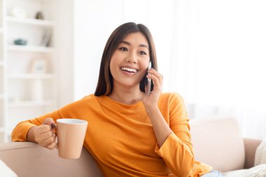 Uzun saçlı güzel Asyalı bir kadın arkadaşlarıyla ya da sevgilileriyle telefonda konuşurken kanepede oturup çay ya da kahve içerek fotokopi odasına bakıyor ve gülümsüyor.