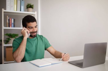 Masada dizüstü bilgisayarı olan, telefonla konuşan, dahili ofisteki müşteriyle konuşan neşeli, bin yıllık Arap adam yöneticisi. İş ve iletişim, sohbet