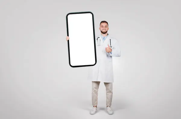 Médico Masculino Positivo Orgullosamente Presenta Una Gran Pantalla Teléfono Inteligente —  Fotos de Stock
