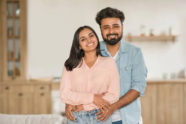 Affectionate young Hindu couple, standing together in their home. The spouses radiate happiness and warmth, reflecting a loving and supportive relationship