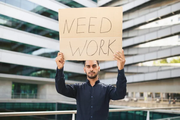 ニードワークペーパーポスターを保持している不幸な中東のビジネスマンは 現代のオフィスビルの外に立っています 失業問題 経済的課題 レイオフの概念 — ストック写真