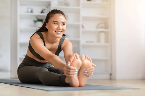Mooie Sportieve Aziatische Vrouw Stretching Benen Tijdens Training Woonkamer Thuis — Stockfoto