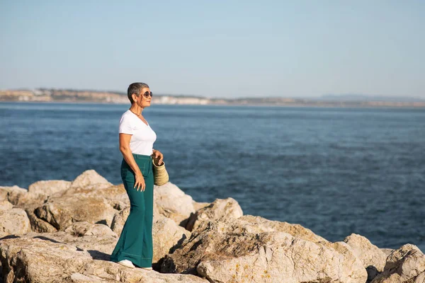 Yaz tatili. Deniz kenarında gezinen, deniz kıyısına yakın duran, deniz kıyısındaki inzivada alacakaranlık anlarının tadını çıkaran bir kadın. Coastal Bliss Konsepti. Boş Boşluk