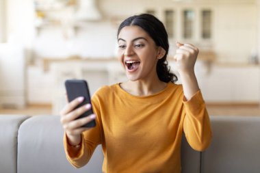 Çevrimiçi Kazanan. Coşkulu Hintli Kadın Akıllı Telefon Tutuyor ve Başarıyı Kutluyor, Mutlu Doğulu Kadın Titreşiyor ve Sevinçle Bağırıyor, İyi Haberlere Duygusal Tepkiler Veriyor, Bedava Uzay