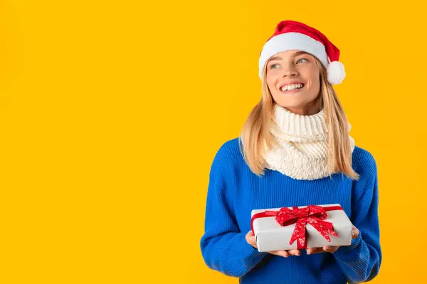 Fröhliche Frau Kuscheligem Pullover Und Weihnachtsmütze Schaut Verträumt Auf Während — Stockfoto