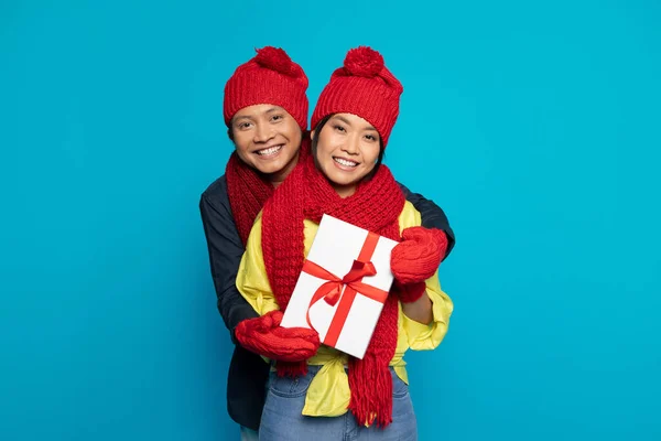 Happy Millennial Asian Guy Hat Show Box Present Hugs Woman — Stock Photo, Image