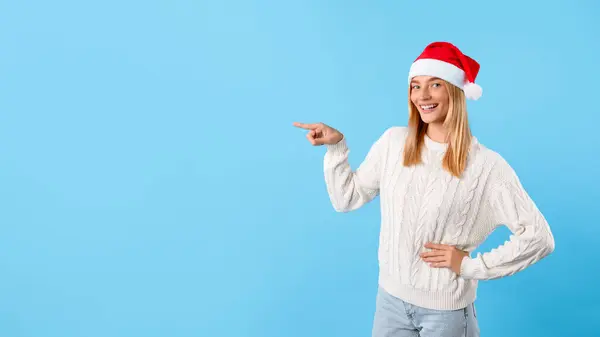 Enthousiaste Jonge Vrouw Met Feestelijke Kerstmuts Vrolijk Naar Zijkant Wijzend — Stockfoto