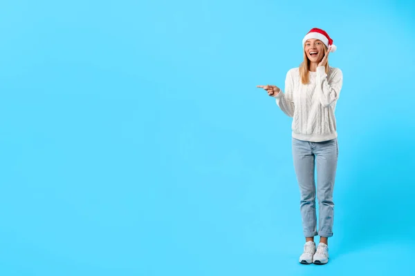 Entzückte Junge Frau Mit Weihnachtsmütze Und Bequemem Weißen Pullover Zeigt — Stockfoto