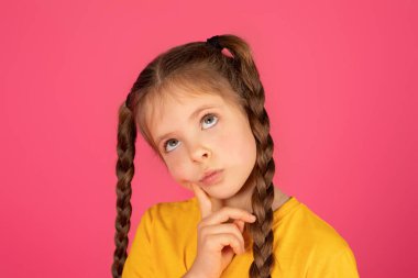 Ergenlik çağındaki bir kızın bir şeyler düşünürken yakın plan fotoğrafı, düşünceli bir kadın çocuğunun portresi, pembe stüdyo arka planında poz verirken çenesine dokunması, fotokopi çekmesi.