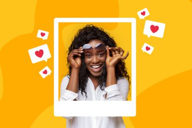 Sosyal medya. Güneş gözlüklü neşeli Afro-Amerikan kadın fotoğraf çerçevesi içinde sarı stüdyo arkaplanına karşı gelen ihbarlar gibi. Bloglama ve SMM. Kolaj
