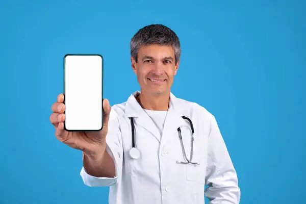 Телемедицинское Предложение Зрелый Доктор Показывает Свой Смартфон Белым Чистым Экраном — стоковое фото