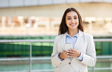 Takım elbiseli, kendine güvenen beyaz bir kadının dışarıda akıllı telefondan yazmayı sevmesine sevindim. İş, girişim, teknoloji ve yaşam tarzı, sosyal ağlarda sohbet uygulaması