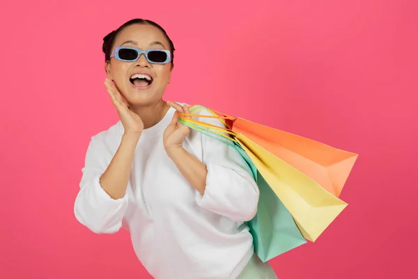 Mulher Asiática Feliz Vestindo Óculos Sol Segurando Sacos Compras Brilhantes — Fotografia de Stock