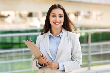 Takım elbiseli, kendine güvenen genç bayan sekreter şehir dışında, kapalı alanda, işin tadını çıkarıyor. İş, girişim, öğrenim ve yaşam tarzı planlaması, reklam ve teklif