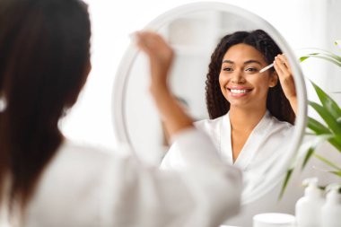 Güzel Siyah Kadın Portresi Nemlendirici Serumu Yüzüne sürerken Aynanın Yanında, Çekici Afrikalı Amerikalı Kadın Günlük Skincare Rutini Yapıyor, Seçici Odaklanma