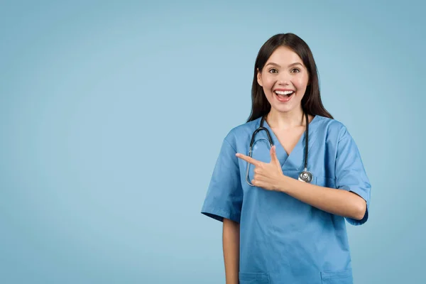 Радісна Молода Медсестра Блакитних Скрабах Спрямована Вільний Простір Яскравою Посмішкою — стокове фото