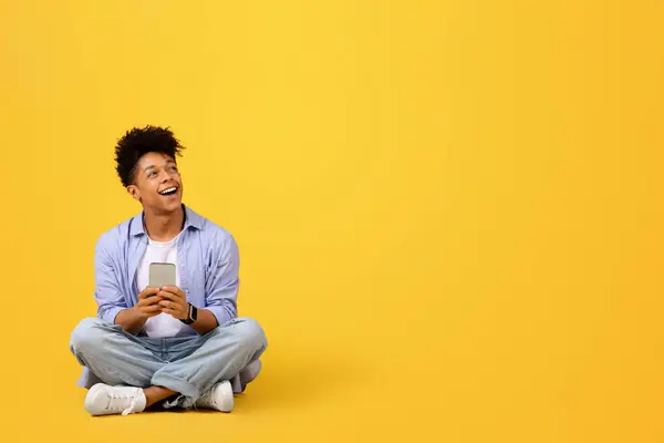 Vzrušený Černošky Student Drží Mobilní Telefon Dívá Stranou Volné Místo — Stock fotografie