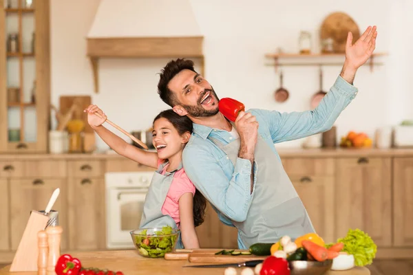Joyful Father Daughter Using Wooden Spoon Bell Pepper Microphones Playfully — Stock Photo, Image
