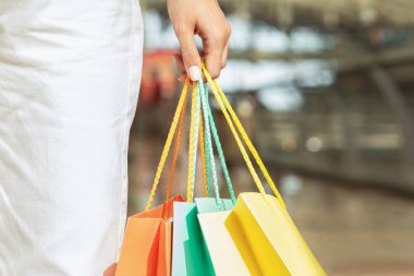 Bin yıllık beyaz kadın elinde bir sürü alışveriş çantasıyla gezmekten, alışveriş yapmaktan zevk alıyor. Kapatın, kırpın. Alışveriş hayatı, satış kıyafetleri ve hediyeler, reklam ve teklif, indirim sezonu.