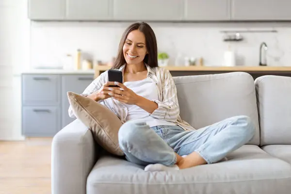 Happy Young European Woman Messaging Smartphone Enquanto Relaxa Sofá Casa — Fotografia de Stock