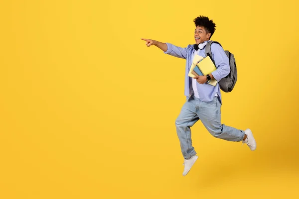 Ενεργητικός Νεαρός Μαύρος Μαθητής Ακουστικά Και Σακίδιο Πηδάει Στον Αέρα — Φωτογραφία Αρχείου