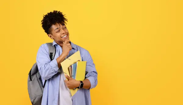 Przemyślany Uśmiechnięty Czarny Student Plecakiem Jednym Ramieniu Trzymający Zeszyty Książki — Zdjęcie stockowe
