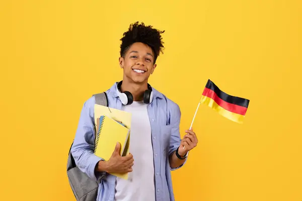 Lächelnder Schwarzer Mann Mit Lernheften Und Deutschlandfahne Mit Kopfhörer Und — Stockfoto