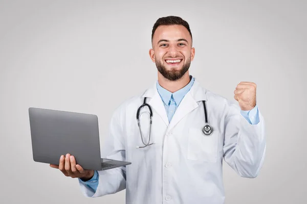 Exuberante Médico Masculino Sosteniendo Computadora Portátil Una Mano Haciendo Gesto —  Fotos de Stock