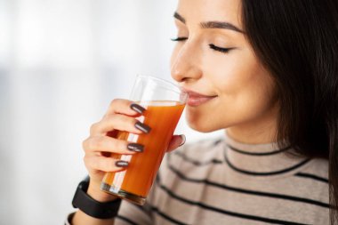 Mutlu genç Arap kadın, odanın içinde bir bardak taze meyve suyu içiyor, kapat. Bayan boş zaman ve diyet, vitamin, sağlık ve kahvaltı, evdeki yaşam tarzı.