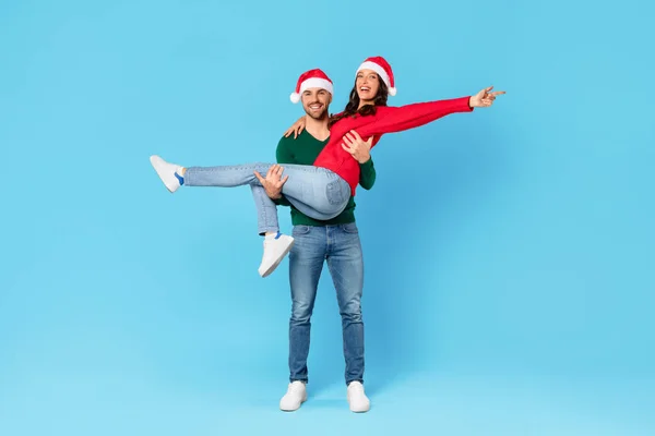 스튜디오에서 모자에 즐거운 남자는 파란색 배경에 크리스마스와 휴일을 여자를 — 스톡 사진