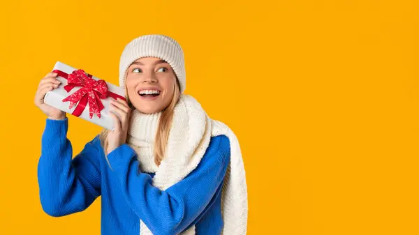 Radostná Mladá Žena Zimním Oblečení Vzrušeně Drží Vánoční Dárek Ukazuje — Stock fotografie
