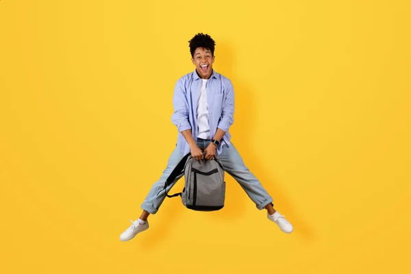Веселий Чорний Хлопець Грайливому Стрибку Повітрі Тримає Рюкзак Широкою Посмішкою — стокове фото