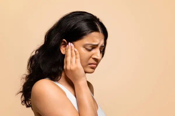 头痛的概念 描述患有偏头痛 恶心的东方女性在站在米色工作室的背景下揉皱眉头 感觉不适的印度年轻女性 — 图库照片