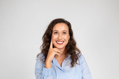 Düşünceli, pozitif, beyaz bir iş kadını, resmi giyinen bir öğretmen. Gri arka plan stüdyo geçmişinde izole edilmiş. Çalışma, öğrenim ve iş fikri oluşturma, reklam ve teklif