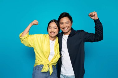 Bin yıllık Japon çiftlerin gelişigüzel yumruklarıyla zaferi, başarıyı, mavi stüdyo geçmişinde izole olmalarını kutluyoruz. Duygular jesti, iyi haber, kazanma işareti, takım çalışması.