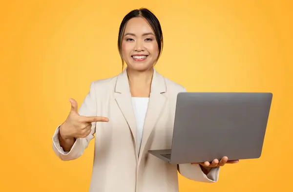Gülümseyen Bin Yıllık Takım Elbiseli Çinli Kadını Bilgisayarı Işaret Eden — Stok fotoğraf