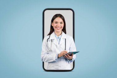 Tıbbi üniformalı genç Avrupalı bayan mavi arka planda online tıbbi konsültasyonu gösteren büyük bir ekranda dijital tablet kullanıyor.