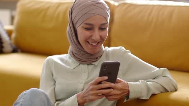 Genç Kaygısız Ortadoğulu Müslüman Kadın Akıllı Telefondan Arkadaşlarıyla Mesajlaşıyor Evde — Stok video